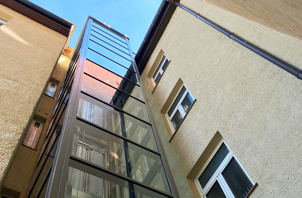 Neubau einer Personenaufzugsanlage über 5 Etagen in einem denkmalgeschützen Wohn- und Geschäftshaus in München